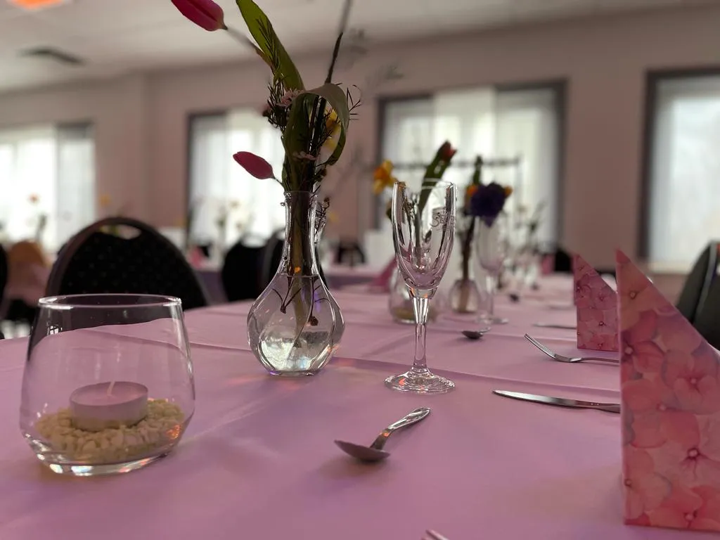 Veranstaltungsraum – gedeckter Tisch mit Blumenvase und Gläsern