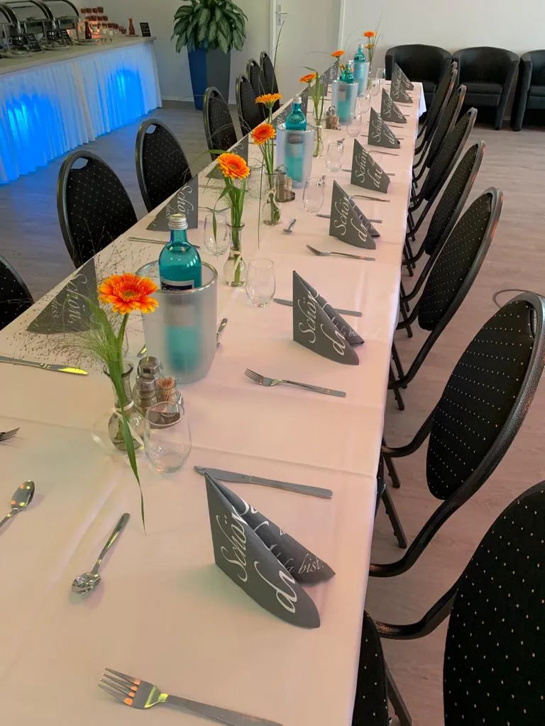 Veranstaltungsraum – gedeckte Tafel mit Gerbera und Buffet